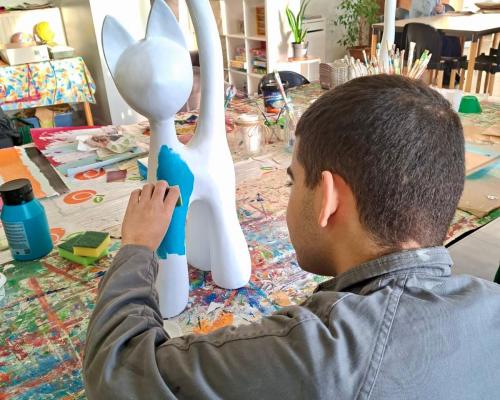 Een cliënt beschildert een beeld in het creatief atelier