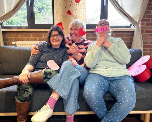 Drie bewoonsters lachen samen in de zetel