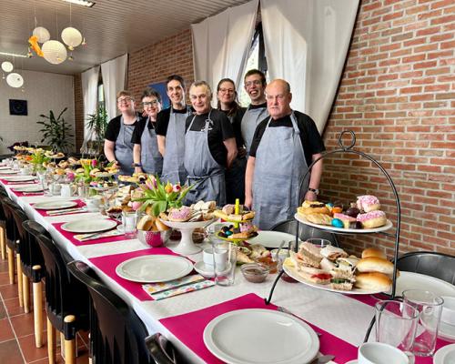 Feestelijk gedekte tafel met de ploeg in schort
