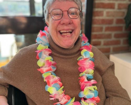 Een stralende bewoonster met een bloemenkrans