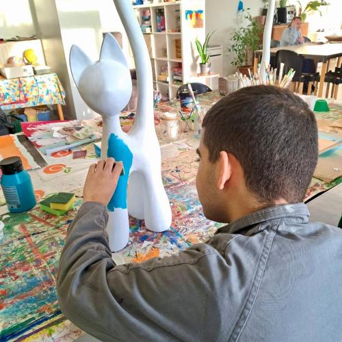 Een cliënt beschildert een beeld in het creatief atelier