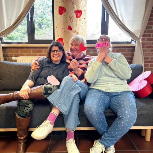 Drie bewoonsters lachen samen in de zetel