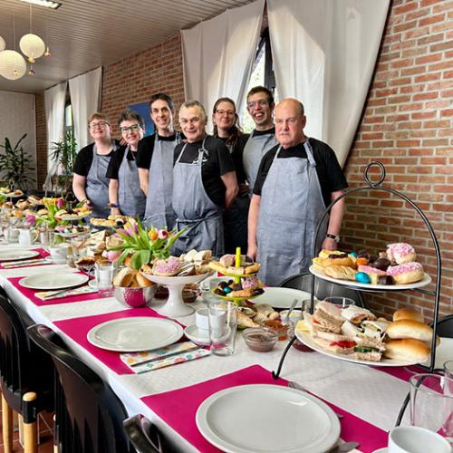Feestelijk gedekte tafel met de ploeg in schort
